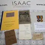 A collection of military memorabilia for Private George Lloyd Dimmock, including medals, documents, a regimental booklet, and a reunion dinner menu, displayed on a patterned surface.